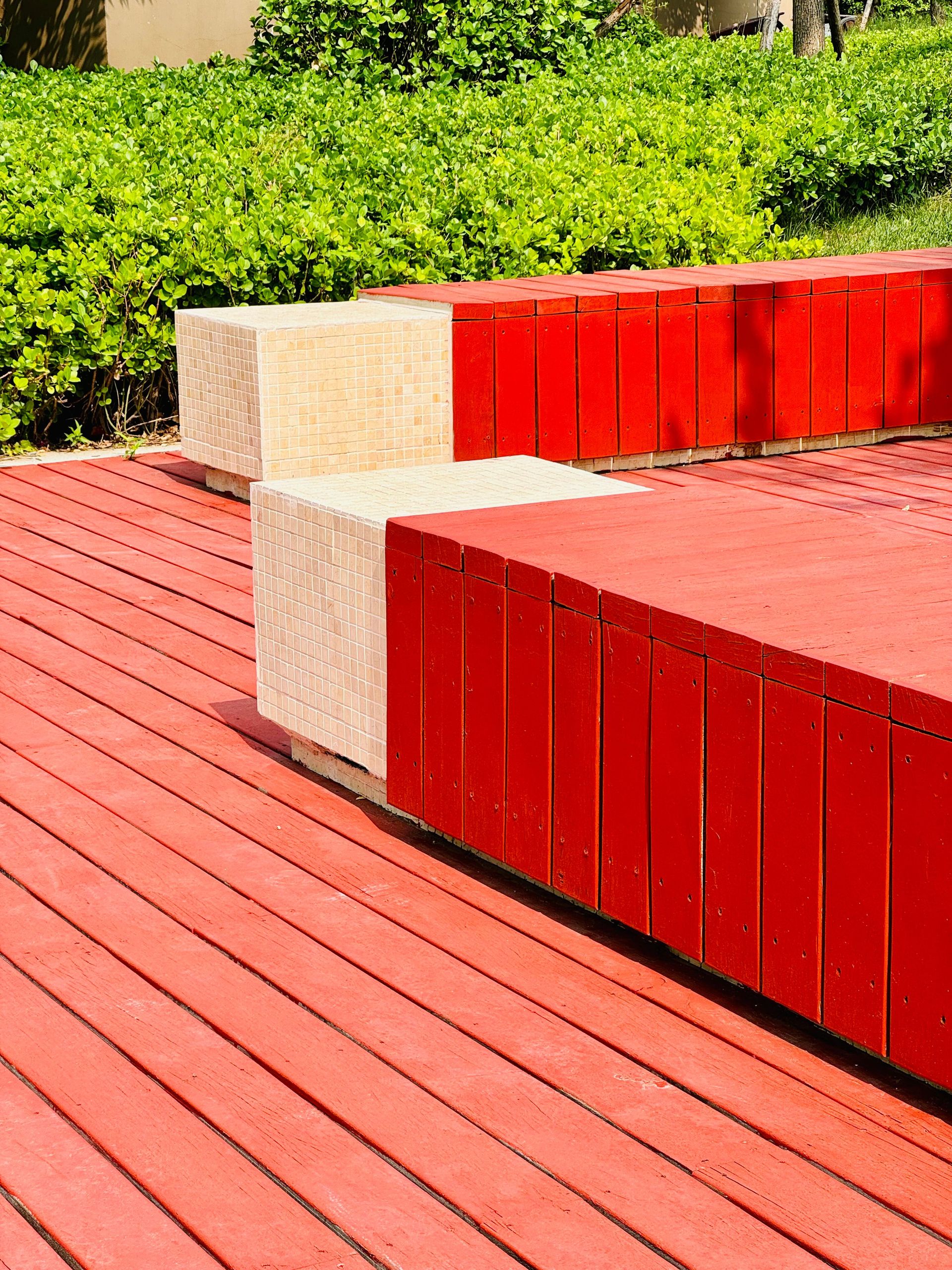 Vibrant red wooden bench in a lush green garden, Dongli District, Tianjin, China.